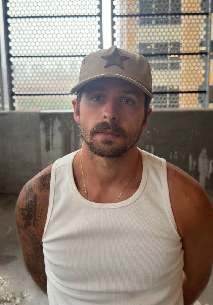 Unstructured tan suede buckle-back hat — front view