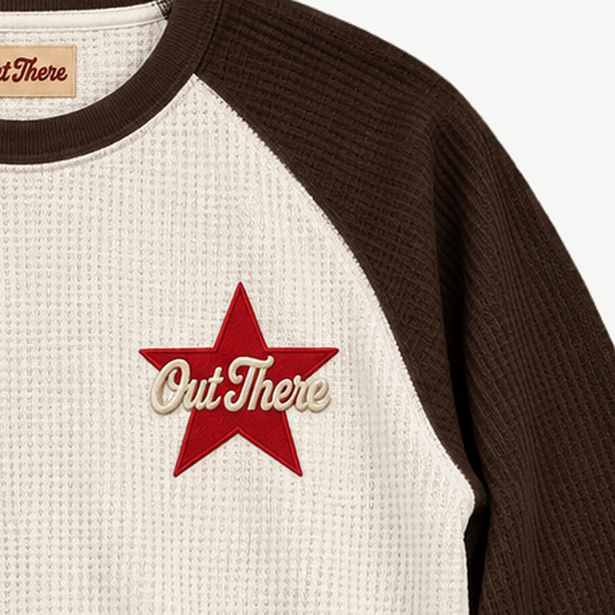 Close-up of the red Out There Star patch on the Egret & Brown Waffle Raglan