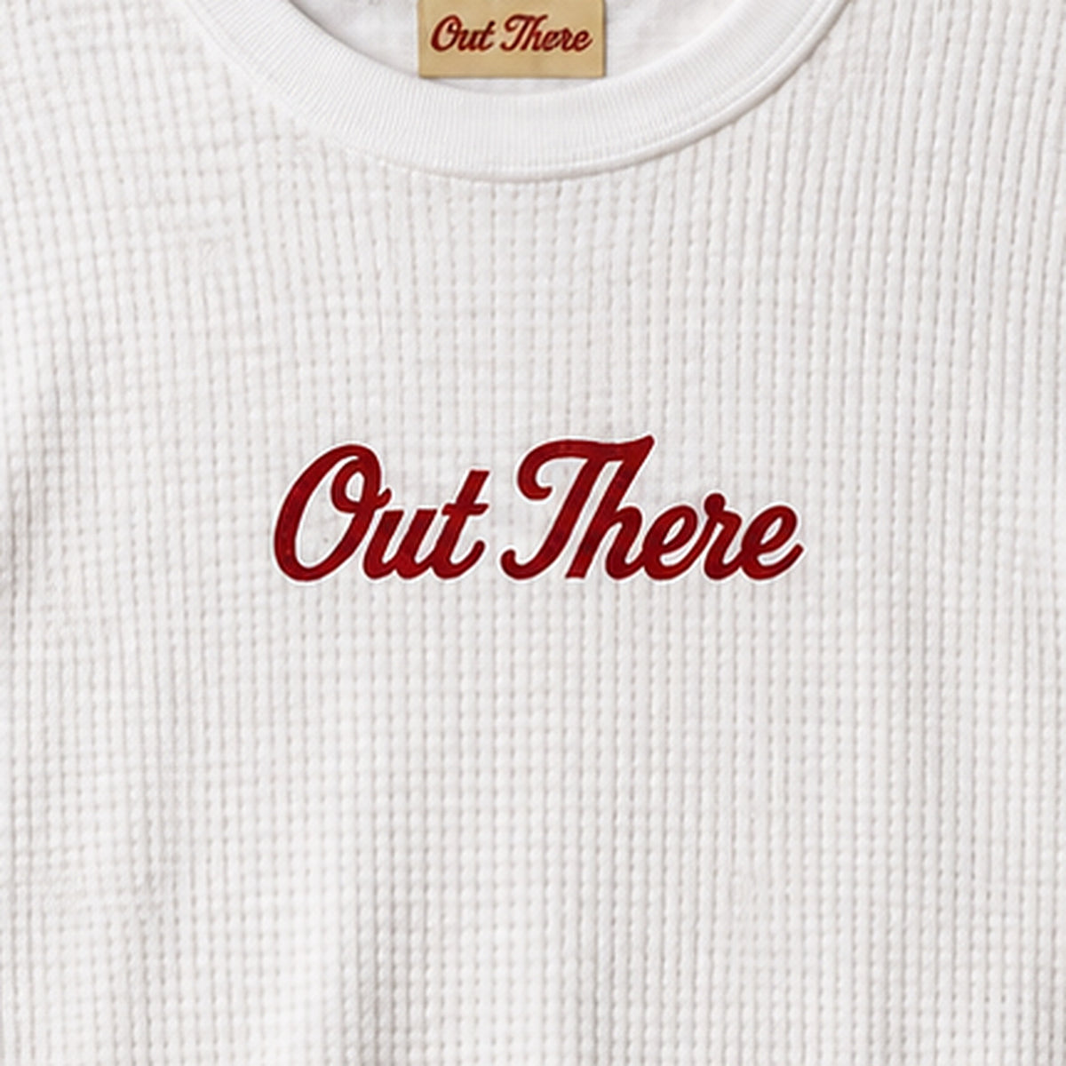 Close-up of the red Out There chest script on the White Waffle Script Long Sleeve
