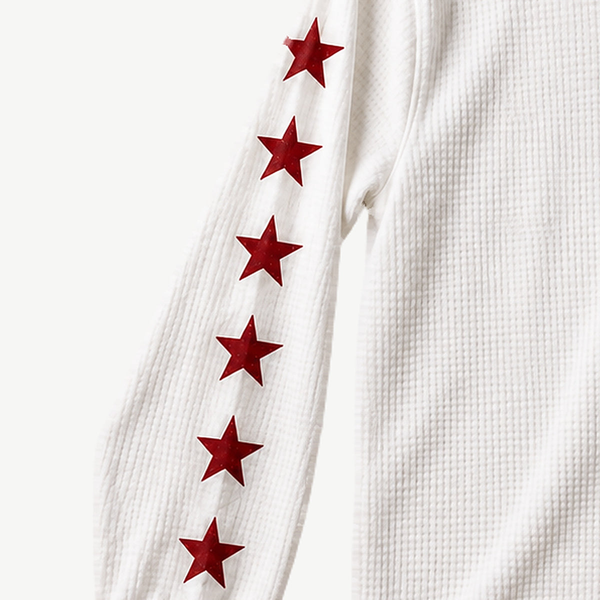 Close-up of the red stars down the sleeve of the White Waffle Script Long Sleeve